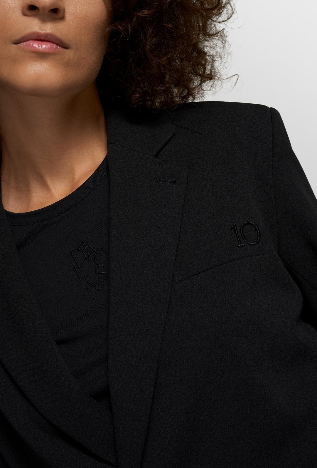 Nowoczesny czarny komplet z krótką marynarką i szerokimi spodniami