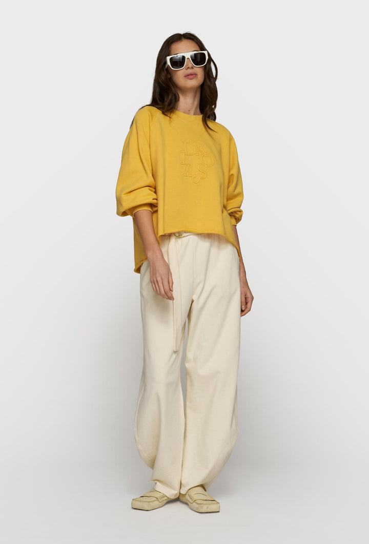 Żółta bluza oversize i kremowe spodnie z paskiem