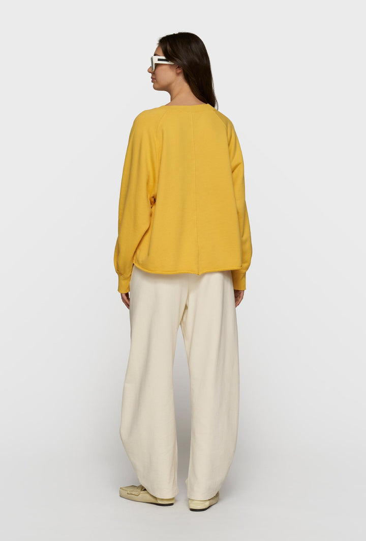 Żółta bluza oversize i kremowe spodnie z paskiem