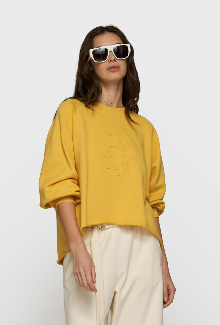 Żółta bluza oversize i kremowe spodnie z paskiem