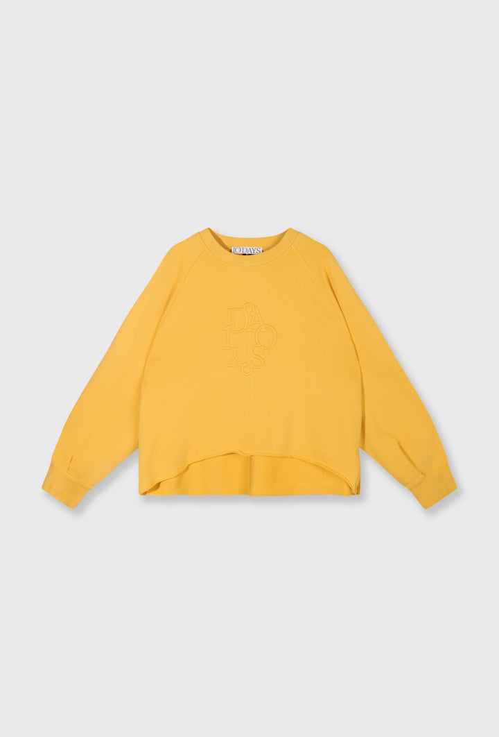 Żółta bluza oversize i kremowe spodnie z paskiem
