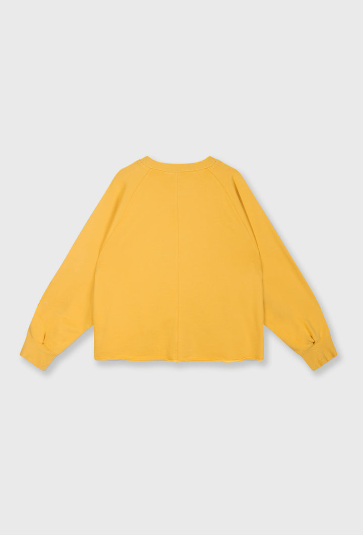 Żółta bluza oversize i kremowe spodnie z paskiem