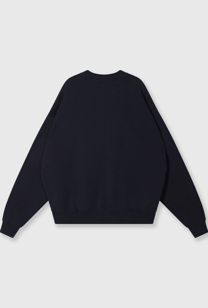 Nierozpinana bluza w granatowym kolorze z widoczną aplikacją z logo marki