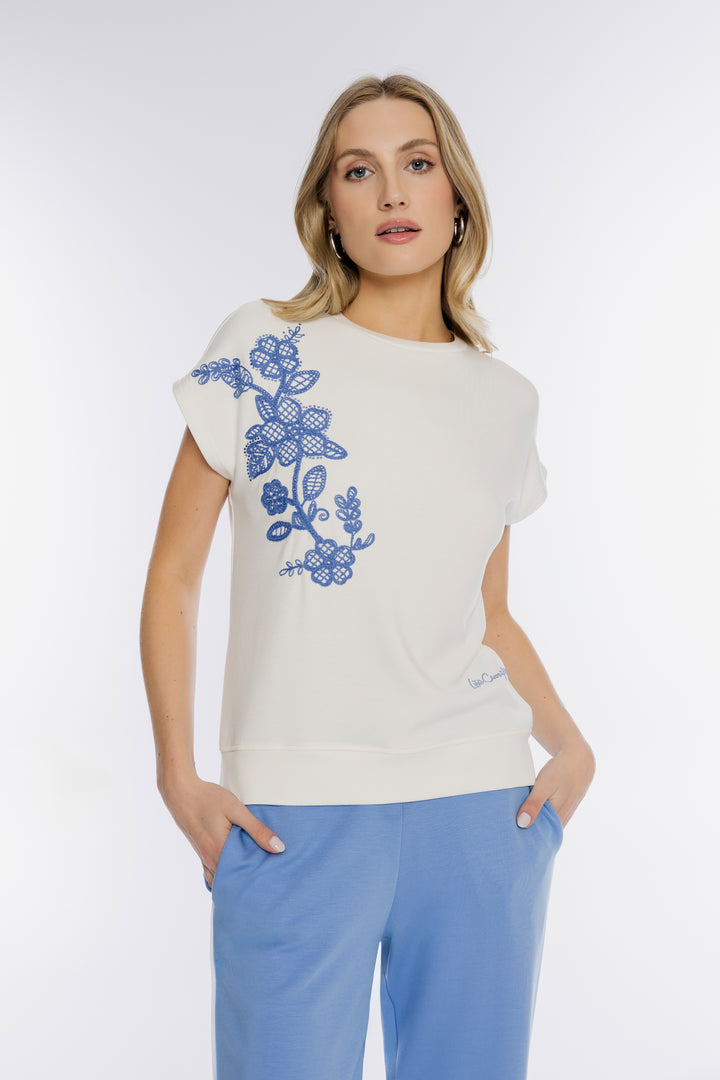 Kremowy t-shirt z haftem i niebieskie spodnie dresowe