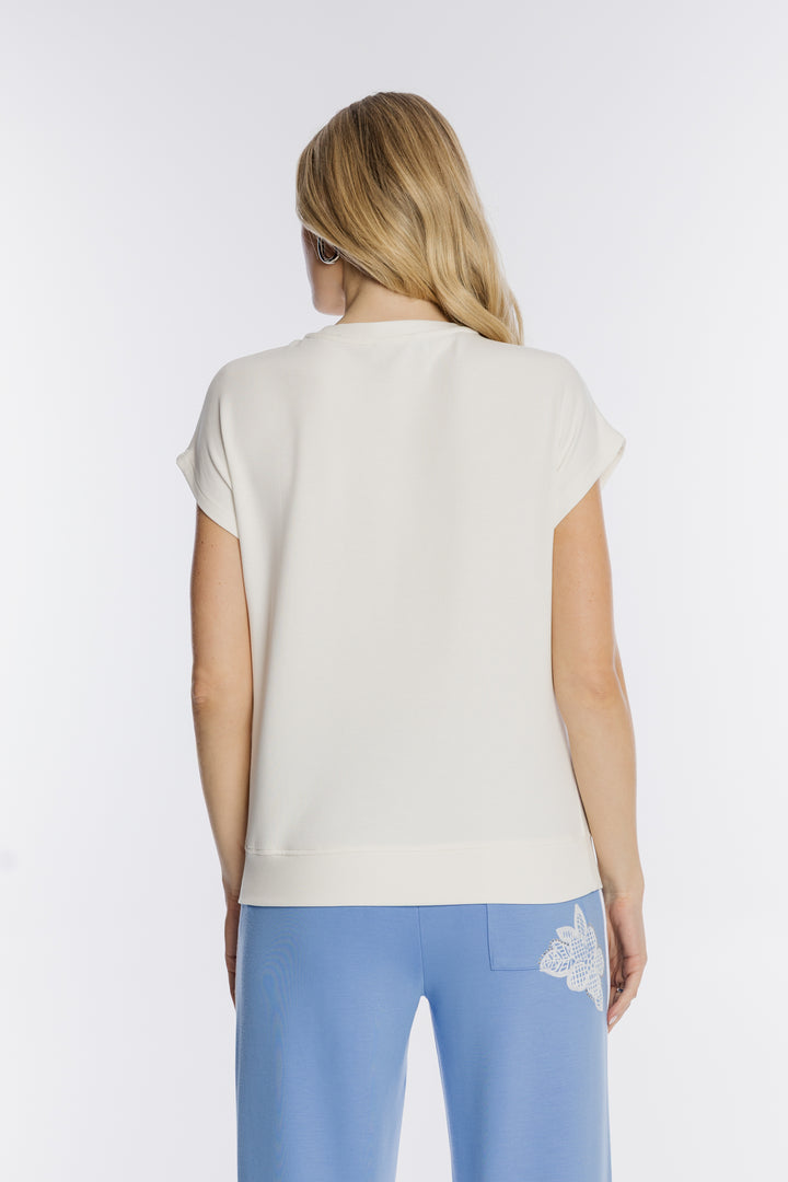 Kremowy t-shirt z haftem i niebieskie spodnie dresowe