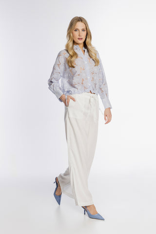 Błękitna koszula z ażurowym haftem i białe spodnie