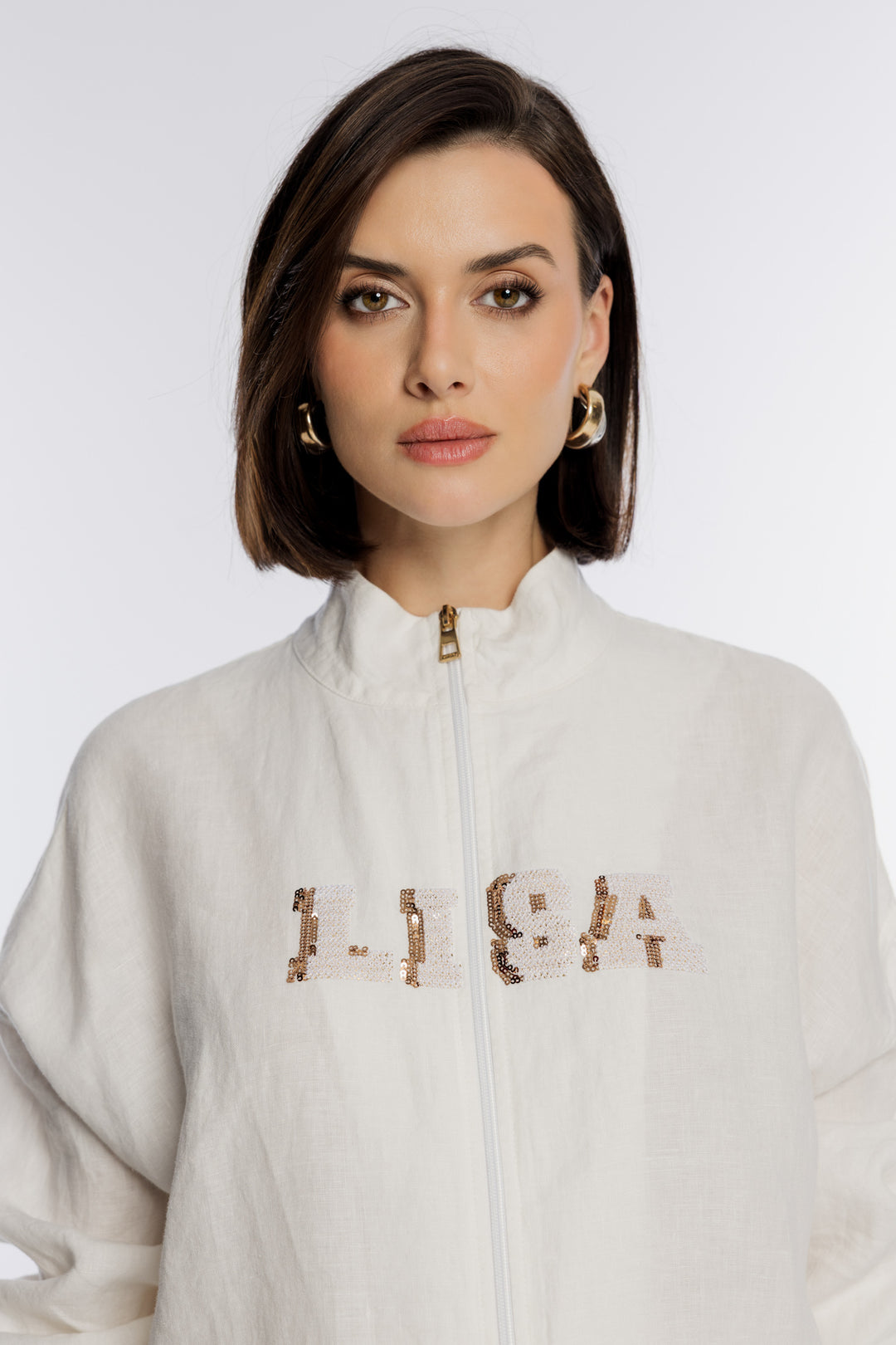 Biała bluza rozpinana ze złotym napisem